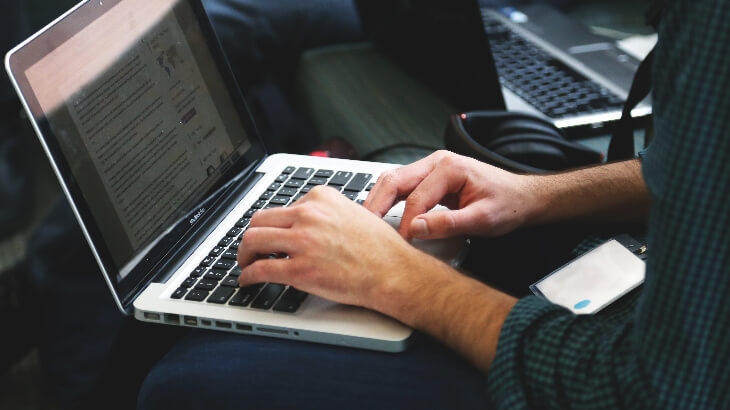 macbookでタイピングをする男性